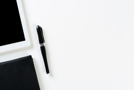 Still life of modern office workspace with supplies. Flat lay white desk with black leather wallet and tablet computer. Online shopping and payment. Creativity and innovation concept with copy space