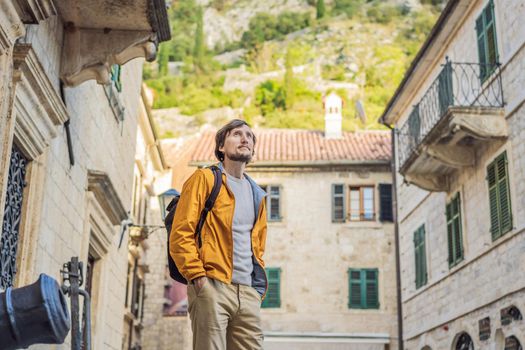 Man tourist enjoying Colorful street in Old town of Kotor on a sunny day, Montenegro. Travel to Montenegro concept.