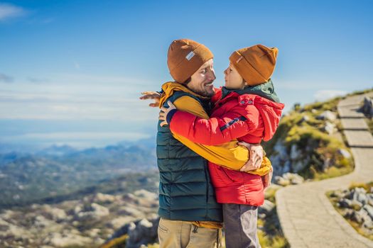 Dad and son travellers in mountain landscape at national park Lovcen, Montenegro. Travel to Montenegro with children concept.