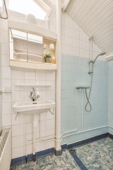 Bathroom decorated with multicolored tiles with sink and shower stall in a modern house