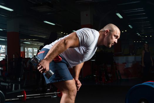 Male bodybuilder engaged with dumbbells in the gym. Healthy lifestyle