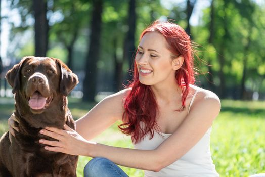 Woman in the park hugs a dog. Spend time with pets