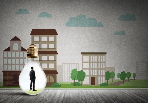 Businessman inside light bulb against city drawn concept