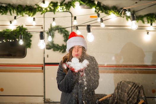 Caucasian woman in santa hat playing snowballs at camper