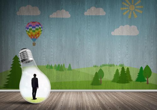 Businessman inside light bulb in room against nature drawn concept