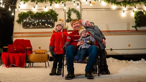 Caucasian man and three sons celebrate Christmas in a mobile home