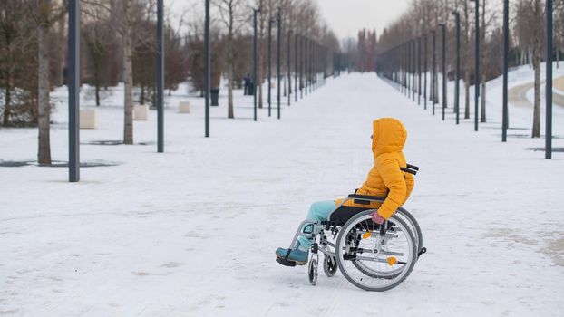 Disabled woman in a wheelchair outdoors in winter