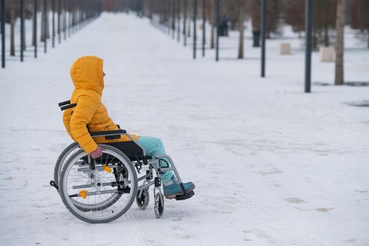 Disabled woman in a wheelchair outdoors in winter