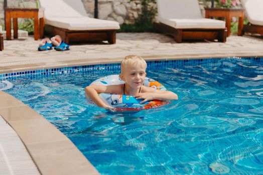 Happy child having fun on summer vacation. Kid playing with rubber duck and ball in the sea. Healthy lifestyle concept. Happy child playing in swimming pool. Summer vacations concept