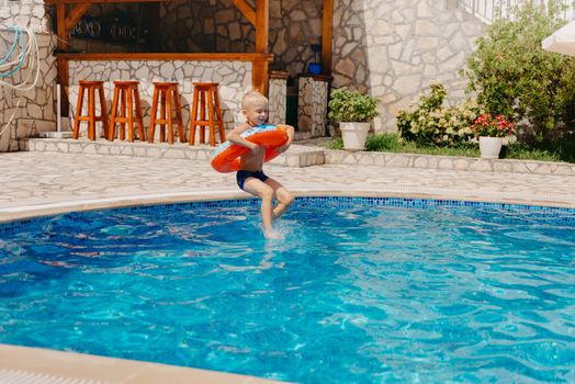 Happy child having fun on summer vacation. Kid playing with rubber duck and ball in the sea. Healthy lifestyle concept. Happy child playing in swimming pool. Summer vacations concept