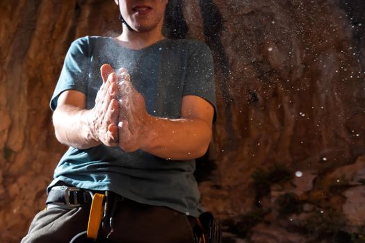 Male hands with magnesia powder close-up against the background of the mountains, the hands of a climber who prepares for outdoor training, a man is engaged in active sports in Greece.