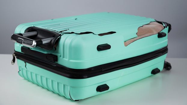 Broken plastic mint suitcase on a white background