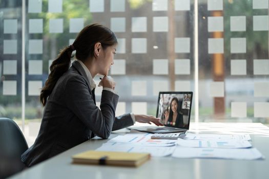 business woman talking to her colleagues about plan in video conference. Multiethnic business team using laptop for a online meeting in video call. Group of people smart working from home.