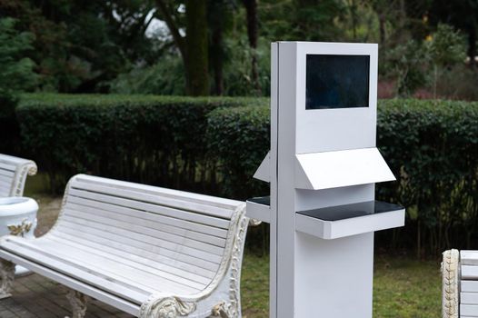 Electronic stand in the park next to the bench