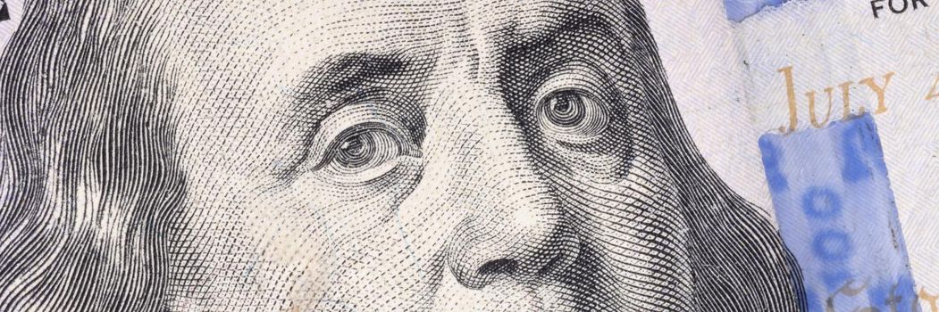 Closeup of Ben Franklin on one hundred dollar bill background. Counterfeiting money concept