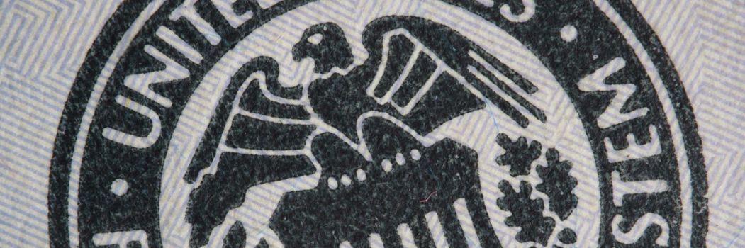 Closeup of coat of arms of United States of America on dollar bill background. America politics and economy concept