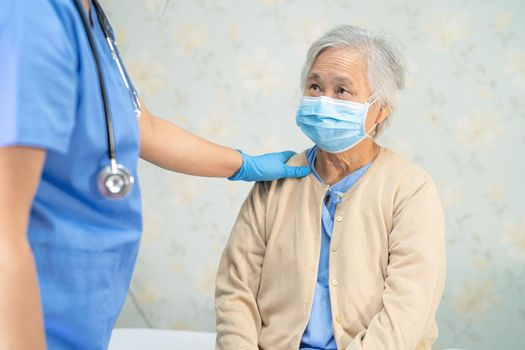 Doctor checking Asian senior or elderly old lady woman patient wearing a face mask in hospital for protect infection Covid-19 Coronavirus.