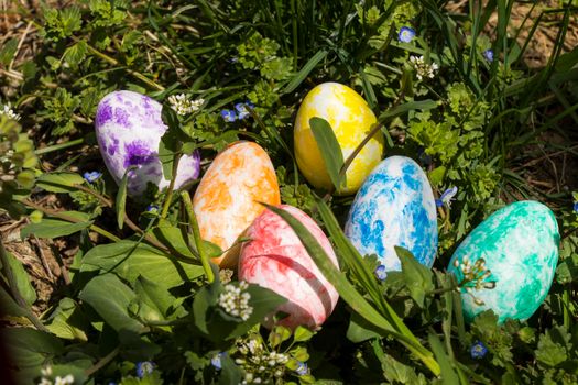 Happy Easter, colorful eggs and flowers. Grass and land.