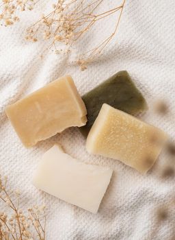 Natural cosmetics. Handmade soap bars on white bathtowel top view. mockup design