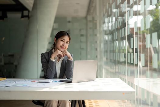 Portrait of attractive asian businesswoman working on laptop for marketing plan financing calculation concept