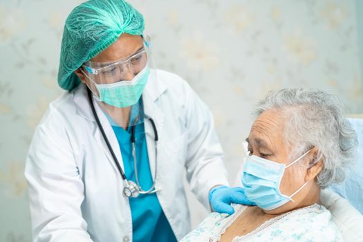 Asian doctor wearing face shield and PPE suit new normal to check patient protect safety infection Covid-19 Coronavirus outbreak at quarantine nursing hospital ward.