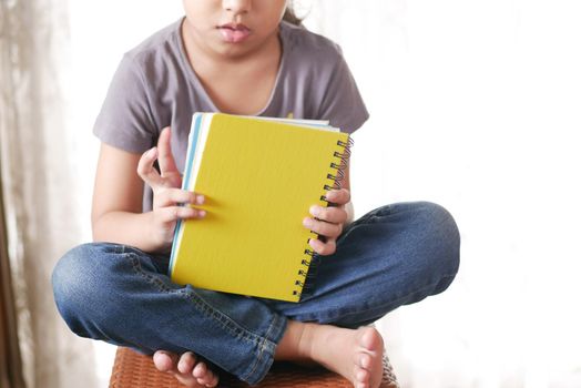 teenage child holding many colorful notepads .