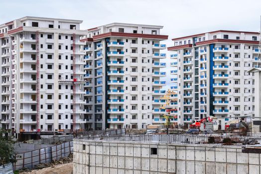 Antalya, Alanya - February 16, 2021: New multi-storey residential complex of modern architecture consisting of three houses at final stage of construction.