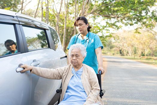 Asian senior or elderly old lady woman patient sitting on wheelchair prepare get to her car, healthy strong medical concept.