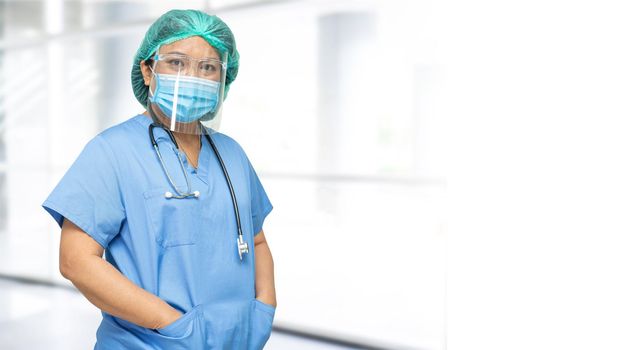 Asian doctor wearing face shield and PPE suit new normal to check patient protect safety infection Covid-19 Coronavirus outbreak at quarantine nursing hospital ward.