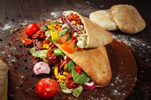 Doner kebab or pita on a wooden tray.