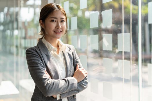 Pretty young business asian woman, successful confidence with arms crossed in financial building