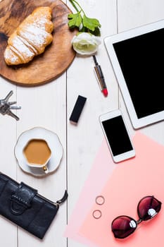 Flat lay, top view, mock up women's accessories on a white background. phone, croissant, a cup of coffee