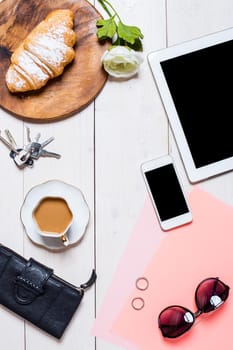 Flat lay, top view, mock up women's accessories on a white background. phone, croissant, a cup of coffee