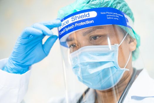 Asian doctor wearing face shield and PPE suit new normal to check patient protect safety infection Covid-19 Coronavirus outbreak at quarantine nursing hospital ward.