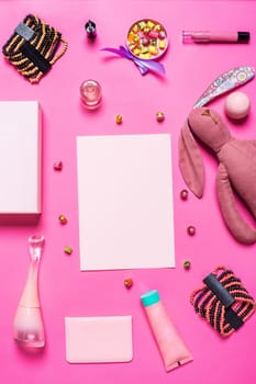 Flat lay, top view, mock up girl's accessories on a pink background. bracelet, rabbit, toy, perfume