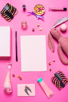 Flat lay, top view, mock up girl's accessories on a pink background. bracelet, rabbit, toy, perfume