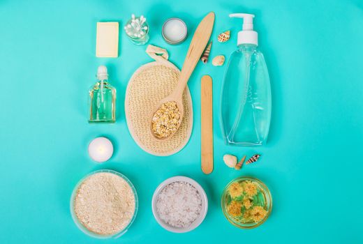 Natural domestic products for skincare on a blue background. Oat, oil, soap, facial cleanser. Top view. Still life. Copy space