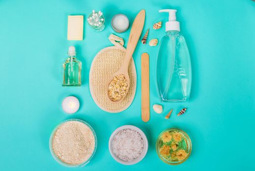 Natural domestic products for skincare on a blue background. Oat, oil, soap, facial cleanser. Top view. Still life. Copy space