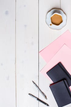 Flat lay, top view, mock up women's accessories on a white background. pen, paper, a cup of coffee, notebook