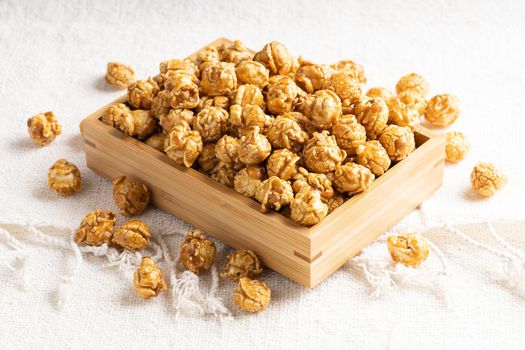 Golden color caramel popcorn in bamboo wooden box, Crunchy and sweet dessert