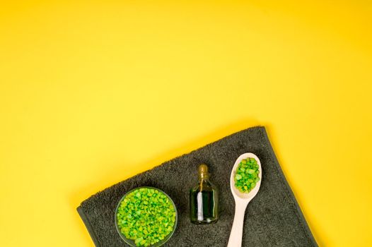 Spa set: soap, mask, oil, sea salt and towel on yellow background. Top view. Still life. Copy space