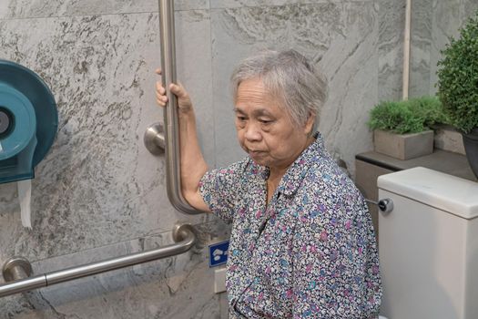 Asian senior or elderly old lady woman patient use toilet bathroom handle security in nursing hospital ward, healthy strong medical concept.