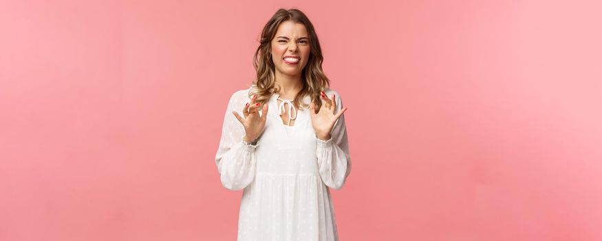 Portrait of girl cringe as telling friend disgusting awful story of her date with guy, show tongue grimacing and press hands to body as feeling discomfort and aversion, stand pink background.