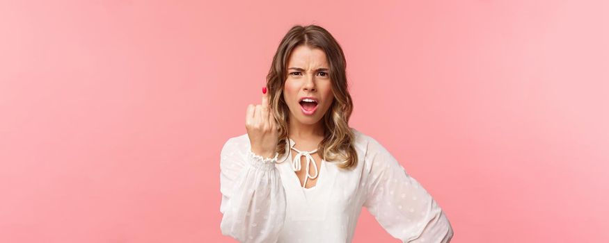 Close-up portrait of pissed-off bothered and fed up blond girlfriend arguing with boyfriend, showing him finger without ring as willing finally get married, standing upset pink background.