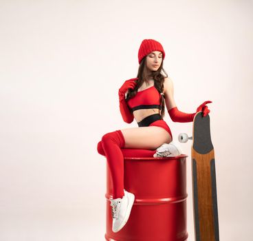 a girl in a red hat with a longboard in short red sports summer clothes