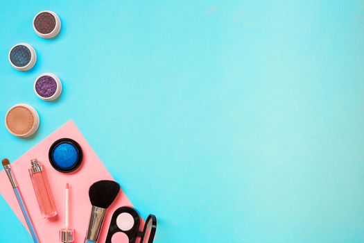 Various cosmetics and brushes on blue background. Top view. Still life. Copy space