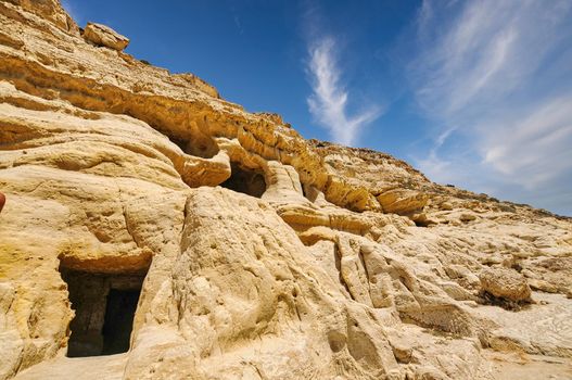 Matala beach with caves on the rocks that were used as a roman cemetery and at the decade of 70's