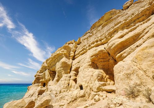 Matala beach with caves on the rocks that were used as a roman cemetery and at the decade of 70's