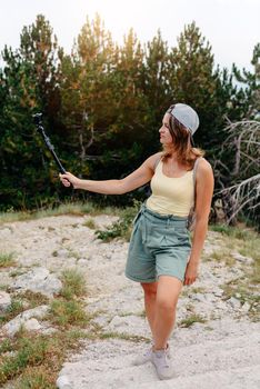 Woman traveler hipster looking forward at amazing mountains and valley view. Space for text. Wearing stylish boho fall outfit. Profile portrait of happy sporty woman relaxing in park. Joyful female model breathing fresh air outdoors. Healthy active lifestyle concept. Copy space.