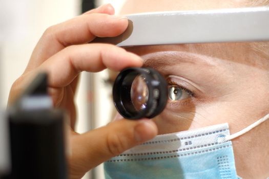 Doctor checks the female patient through the magnifying glass